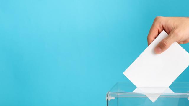 Man putting ballot into voting box on blue background